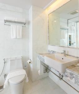 Baño blanco con aseo y lavamanos en The Bloc Hotel - SHA Extra Plus, en Patong Beach