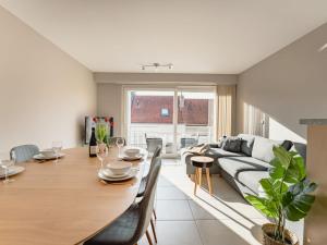 a living room with a table and a couch at Apartment Zandloper with balcony by Interhome in Bredene
