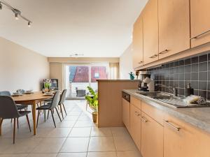 a kitchen with a table and a dining room at Apartment Zandloper with balcony by Interhome in Bredene