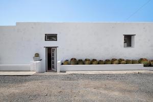 a white building with a row of baskets on it at El Cello in Mácher