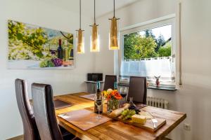 a dining room with a wooden table and a window at Ferienwohnung Kuckucksnest in Lahr