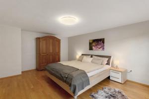 a bedroom with a large bed and a wooden cabinet at You R Welcome in Lauterbach