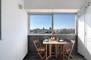 a table and chairs on a balcony with a large window at Apartamento Freire in Portimão