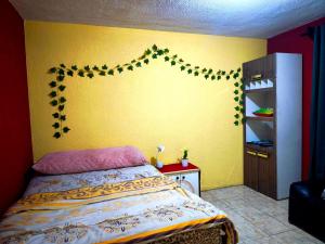 a bedroom with a bed and a yellow wall at Casa Mary's in Quetzaltenango
