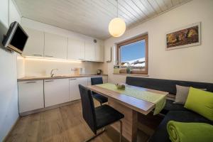 a kitchen and living room with a table and a couch at Ferienwohnung Mittager Edelweiss in Avelengo