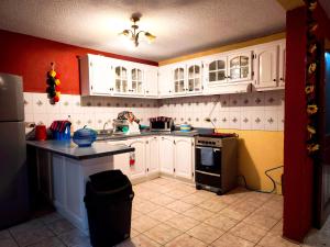 a kitchen with white cabinets and a black counter top at Casa Mary's in Quetzaltenango