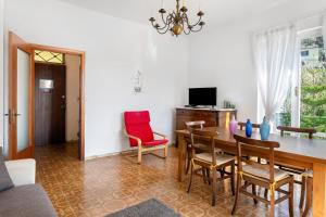 a living room with a dining room table and red chairs at Il Noce - vicino Chiavari in Leivi