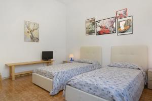 a bedroom with two beds and a table with a tv at Il Noce - vicino Chiavari in Leivi