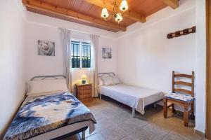 a bedroom with two beds and a chair and a window at Casa Andrea in Barbate +23 photos