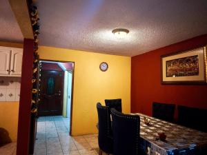 a dining room with a table and a clock on the wall at Casa Mary's in Quetzaltenango +6 photos