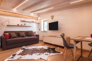 a living room with a couch and a tv at Majon Baticher in Canazei