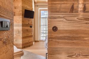 a room with a wooden wall with a door at Majon Baticher in Canazei +18 photos