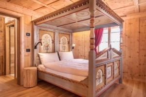a bedroom with a canopy bed in a wooden room at Majon Baticher in Canazei