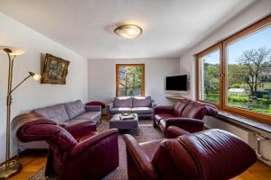 a living room with leather furniture and a tv at Haus an der Lauchert in Veringenstadt