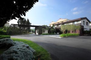 a parking lot with a house and a driveway at Holly Wood Motel in Pitou
