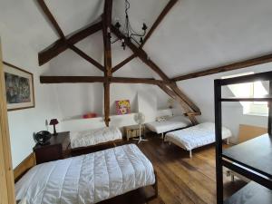 a bedroom with two beds and a ceiling with beams at Maison de Vacances Chez La Prade in Salagnac