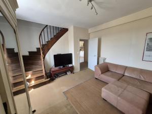 a living room with a couch and a staircase at Maison de Vacances Chez La Prade in Salagnac
