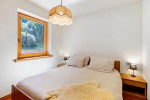 a bedroom with a large bed with a window at Cima de' Piazzi Apartment 2 in Valdidentro