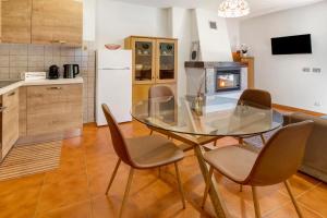 a kitchen with a glass table and chairs in a room at Cima de' Piazzi Apartment 2 in Valdidentro +9 photos