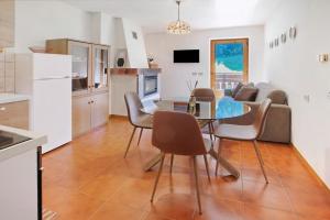 a kitchen and living room with a table and chairs at Cima de' Piazzi Apartment 2 in Valdidentro