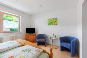 a bedroom with two chairs and a bed and a window at Gästehaus Hanni in Todtmoos