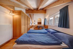 a bedroom with a large bed with blue sheets at Residence Montebel Studio in Tesero