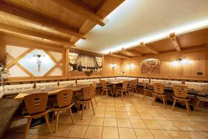 a restaurant with tables and chairs in a room at Residence Montebel Studio in Tesero