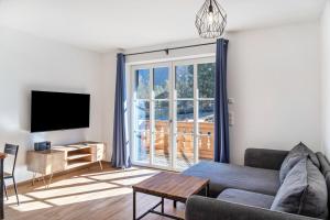a living room with a couch and a tv at Beim Klarwein in Farchant