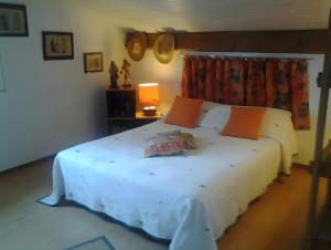 a bedroom with a large white bed with orange pillows at Villa Gastandeia in Cambo-les-Bains