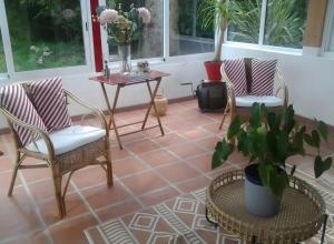 a patio with two chairs and a table with a potted plant at Villa Gastandeia in Cambo-les-Bains