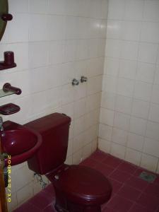 a bathroom with a red toilet and a sink at Hotel Pinangsia in Jakarta