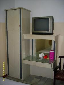 a tv sitting on top of a shelf with a microwave at Hotel Pinangsia in Jakarta