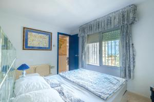 a blue bedroom with a bed and a window at Maison Mer Peniscola in Peniscola