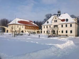 a large white building with snow on the ground at Ferienwohnung Gut Börtewitz in Leisnig