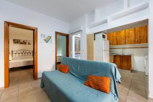 a living room with a blue couch and a kitchen at Villa Loli 2 in El Pozo de los Frailes