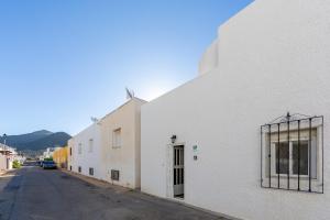 a white building with a window on a street at Villa Loli 2 in El Pozo de los Frailes