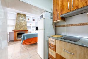a kitchen with a stove and a table and a fireplace at Villa Loli 2 in El Pozo de los Frailes +11 photos