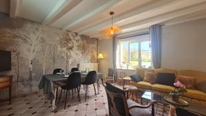 a living room with a couch and a table and chairs at Maison Olei-Villa 3 chambres 6 personnes Terrasse Parking in Oëlleville