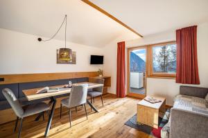 a living room with a table and chairs and a couch at App Hubertus - Wasserfallspitz in Sand in Taufers