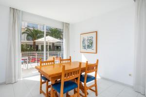 a dining room with a wooden table and chairs at Apartamento Via Alemanya in Can Picafort