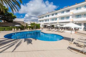 a swimming pool in front of a hotel at Apartamento Via Alemanya in Can Picafort