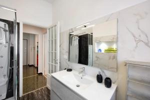 a white bathroom with a sink and a mirror at Il ciliegio di Miki in Genoa