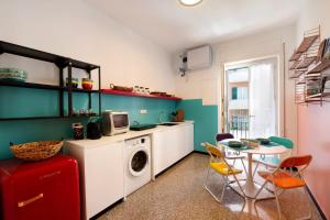 a kitchen with a washing machine and a table with chairs at Il ciliegio di Miki in Genoa +17 photos