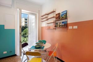 a dining room with a table and chairs and a window at Il ciliegio di Miki in Genoa