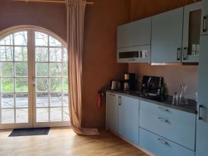 a kitchen with white cabinets and a large window at bund Ferienwohnung in Lenzen
