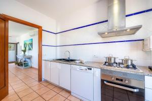 a kitchen with white cabinets and a stove top oven at Ran de Mar in Son Serra de Marina