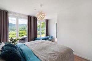 a bedroom with a bed and a large window at Ferienwohnung Luftige Auszeit in Bühlertal