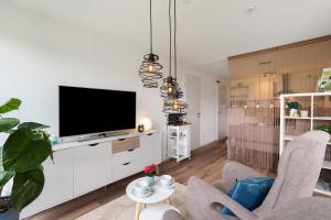 a living room with a flat screen tv on a white cabinet at Ferienwohnung Luftige Auszeit in Bühlertal