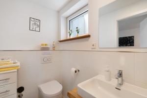 a white bathroom with a sink and a toilet at Ferienwohnung Luftige Auszeit in Bühlertal +20 photos