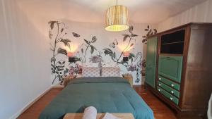 a bedroom with a green bed with a floral wallpaper at Maison Olei-Villa 3 chambres 6 personnes Terrasse Parking in Oëlleville